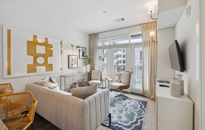 a living room with a white couch and a large window at Link Apartments® Broad Ave, Memphis
