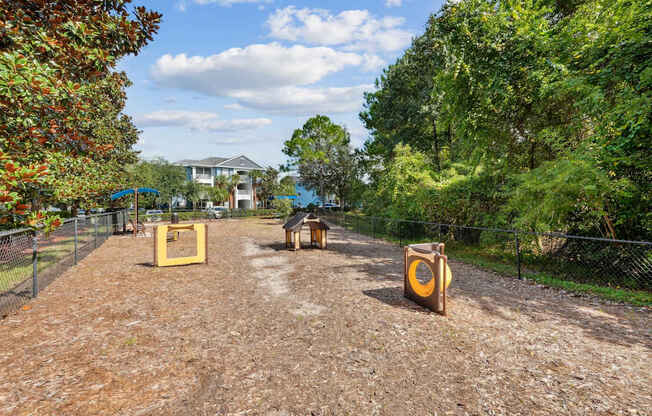 A fenced dog park with toys at Wynnfield Lakes Apartments in Jacksonville, FL