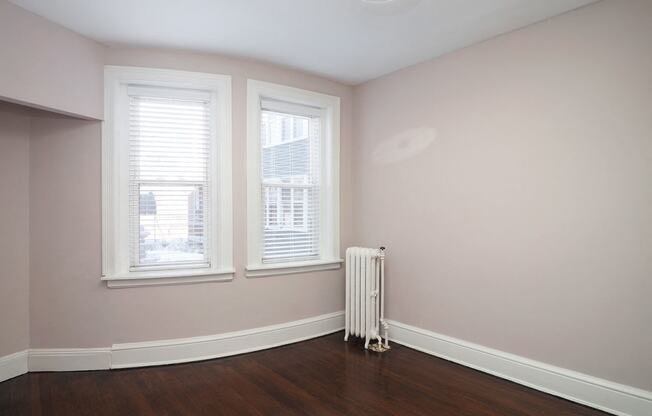 an empty room with a radiator and three windows at The Packard, Connecticut