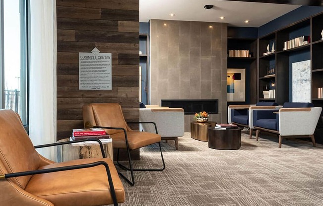 a lobby of a hotel with chairs and a fireplace