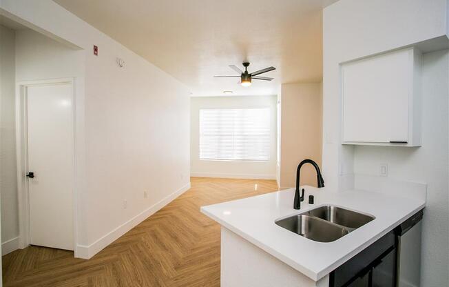 a kitchen with a sink and a ceiling fan