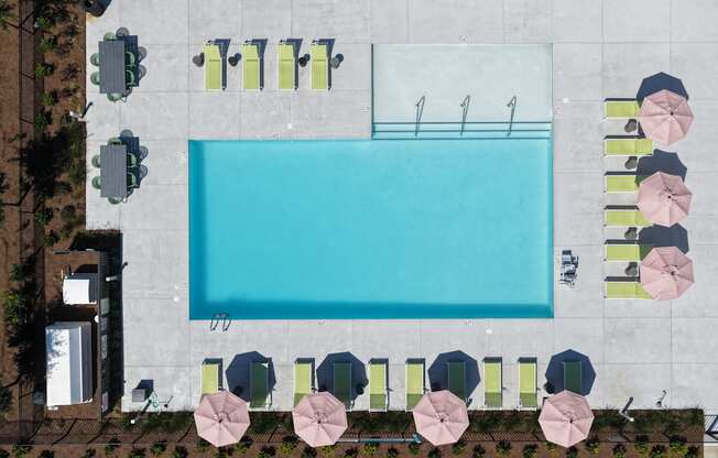 A large rectangular pool surrounded by chairs and umbrellas.