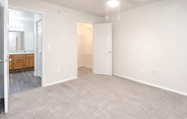 A room with a carpeted floor and a ceiling fan.