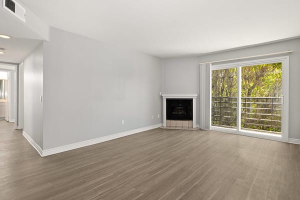 an empty living room with a fireplace and a large window at NOHO GALLERY Apartments, California