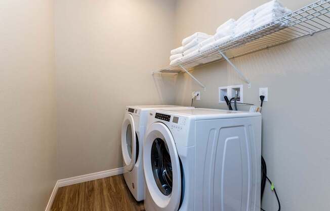 A white dryer and washer are in a small laundry room.