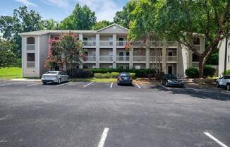 a parking lot with cars in front of an apartment building