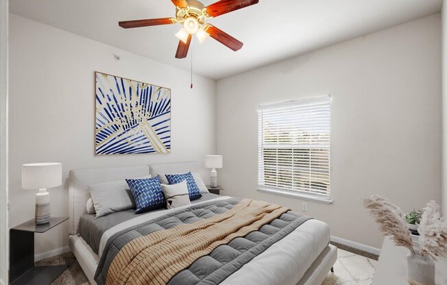 a bedroom with a bed and a ceiling fan