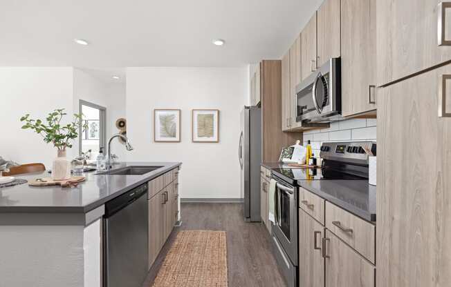 a modern kitchen with stainless steel appliances and wooden cabinets at Palm Grove in Ellenton, FL 34222