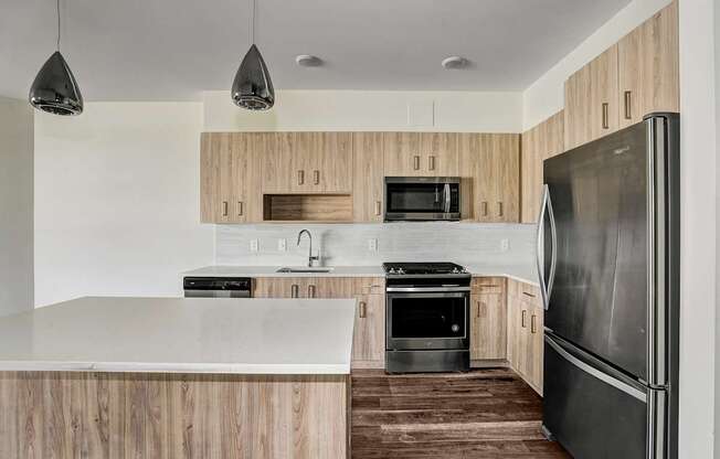 A modern kitchen with wooden cabinets and stainless steel appliances.