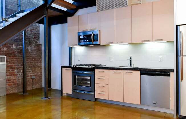 A kitchen with a stainless steel refrigerator and a black countertop.at Arc Light, San Francisco, CA 94107