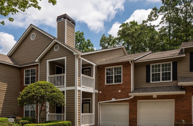 View of Building, Showing Apartment Building, Patio, Balcony, and Attached Garages at Retreat at Peachtree City Apartments