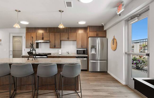 A kitchen with a bar area and grey chairs.