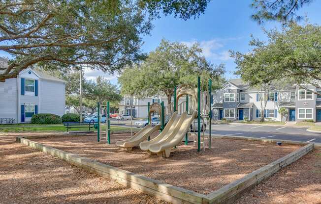 A playground with a slide and a wooden fence.
