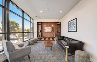 a living room with couches chairs and a coffee table in front of a large window