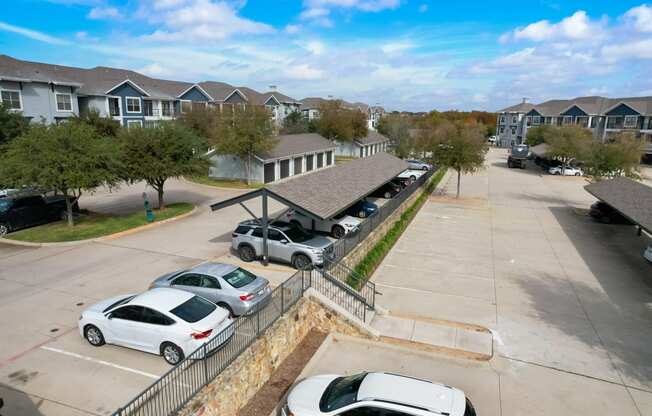 a parking lot with cars parked in front of houses