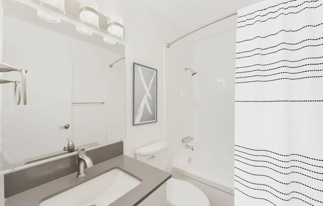 A bathroom with a sink, toilet, and shower.