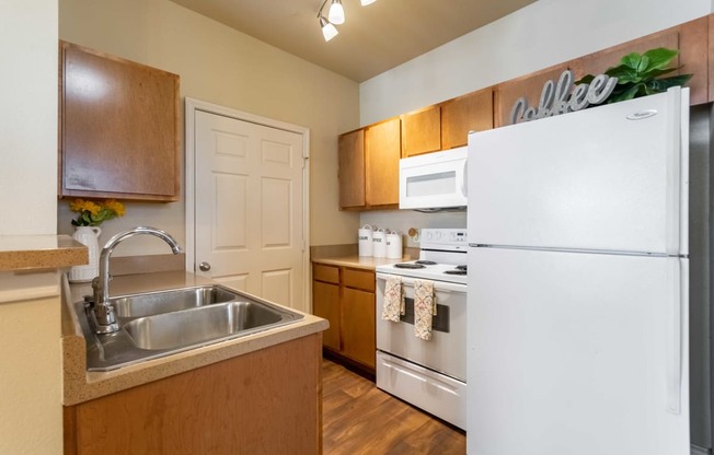 a kitchen with a white refrigerator freezer next to a white stove top oven