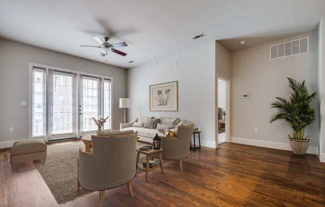 a living room with a couch and chairs and a ceiling fan