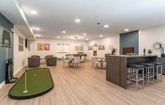 A room with a miniature golf hole in the middle.