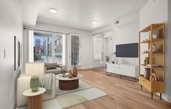 A modern living room with a flat screen TV and a view of the city.