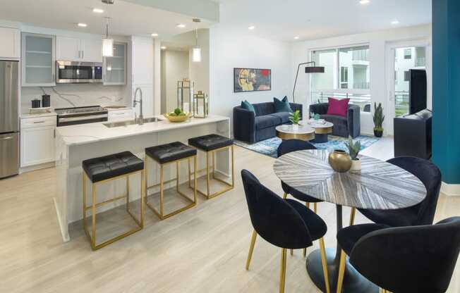 Apartments in Woodland Hills, CA for Rent - The Q Variel - Dining Area, Kitchen, and Living Room with an Open-Concept Layout, Luxury Wood Plank Style Flooring, High Ceilings, Modern Light Fixtures, and Expansive Windows