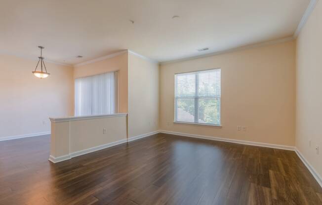 an empty living room with hardwood floors and a window