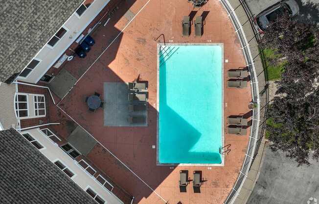 A swimming pool surrounded by lounge chairs and umbrellas.