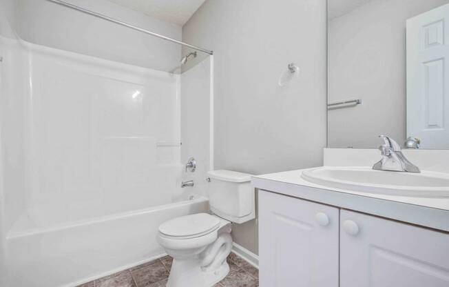 a white bathroom with a sink and a toilet