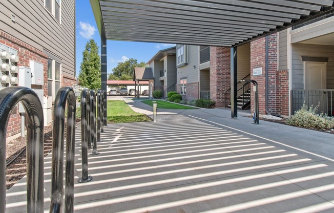 a covered walkway at the whispering winds apartments in pearland, tx