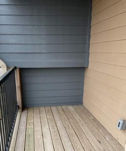 A sunroom with a wooden wall and a black metal grate.