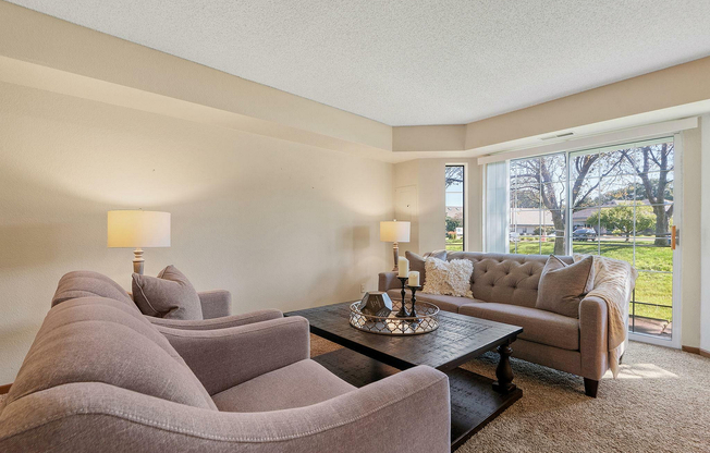 Relax in style in this elegantly designed living room, featuring ample natural light and luxurious furnishings.