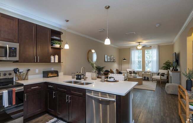 A modern kitchen with dark wood cabinets and stainless steel appliances.