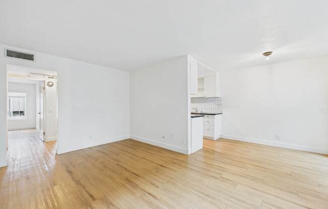 A room with wooden flooring and white walls.