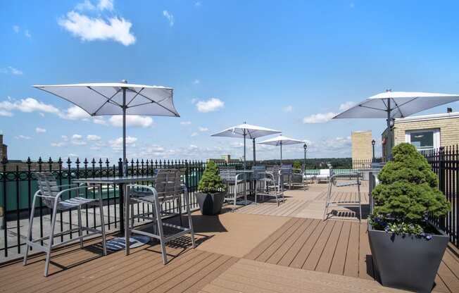 a roof top patio with tables and chairs and umbrellas