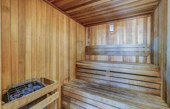 A wooden sauna with a bench and a hot tub.