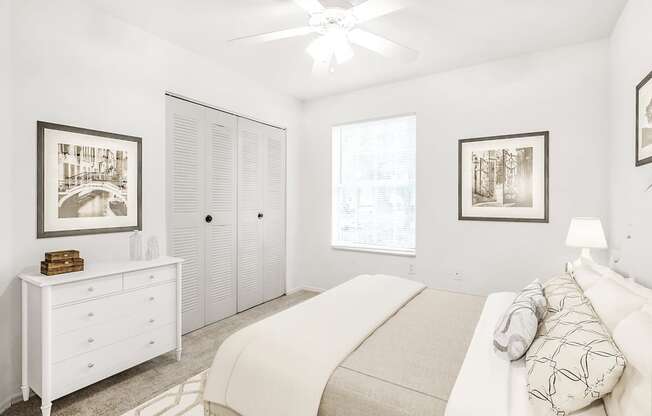 Virtually staged bedroom with carpet, accent rug, ceiling fan with light, white dresser, closet, and large window