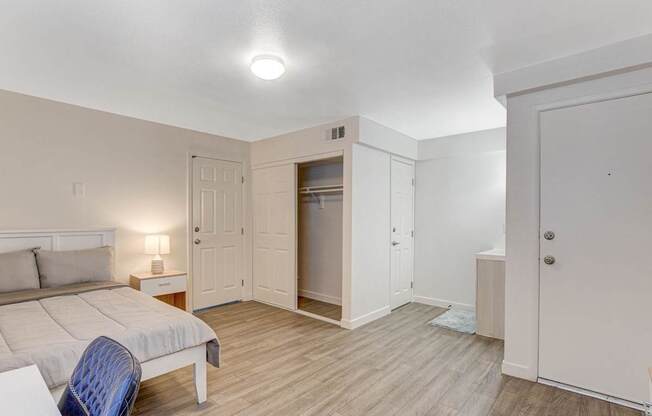 A bedroom with a bed, chair, and wardrobe.
