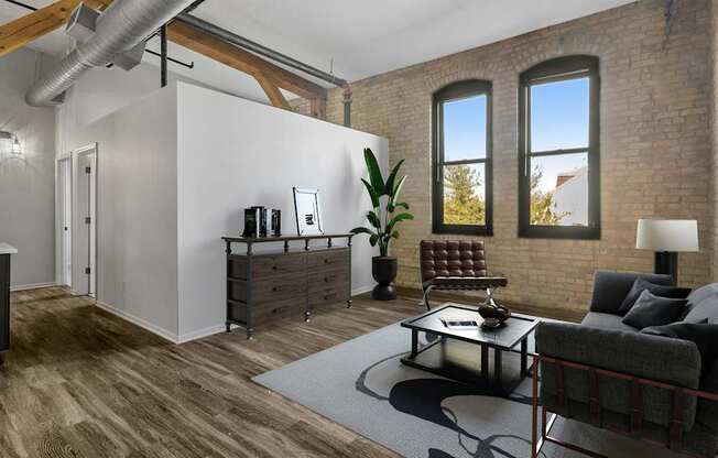 A living room with a grey couch and a black and white rug.