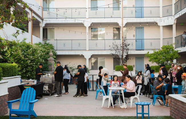 a group of people sitting at tables on a patio outside of a building