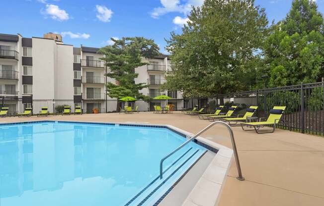 A swimming pool surrounded by yellow chairs and trees.