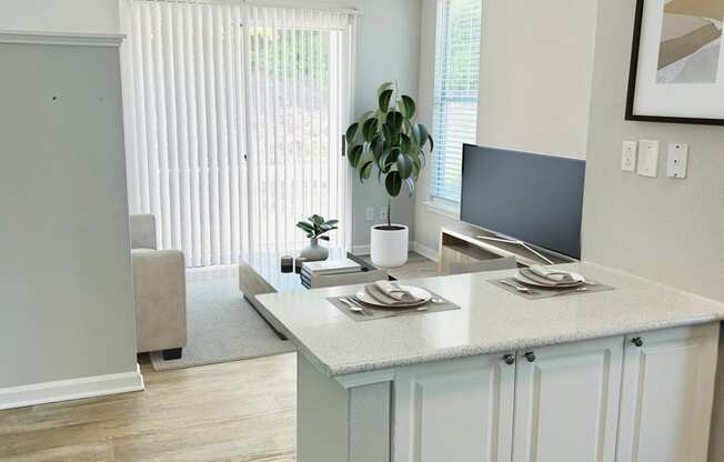 a kitchen with an island and a tv in a living room