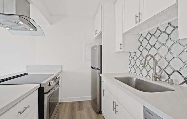 A kitchen with white cabinets and a black stove top oven.