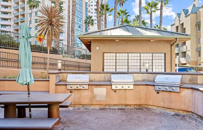 A patio with a table, chairs and a grill.