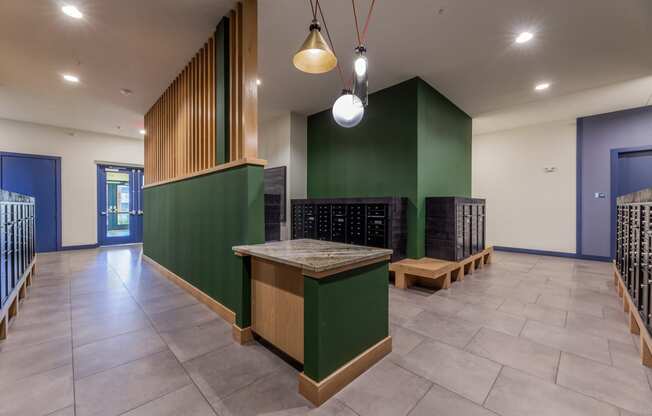 a large room with a table and benches in front of a green wall