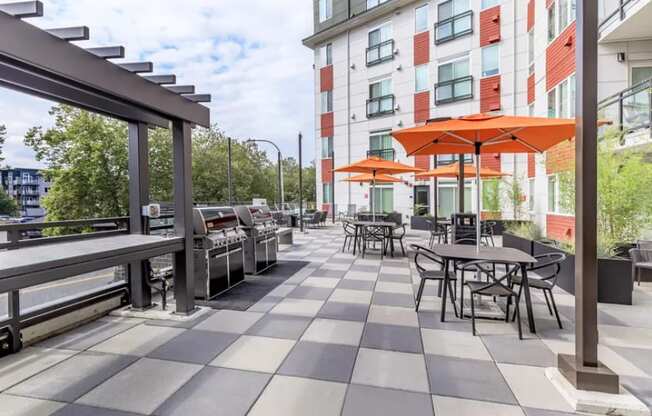 A patio with tables and chairs and umbrellas.