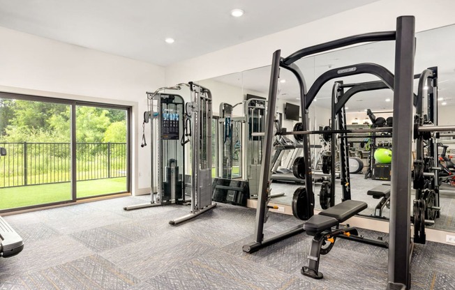 a gym with exercise equipment and a glass sliding door