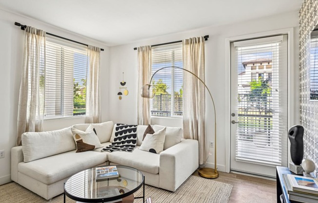 a living room with a white couch and a glass coffee table