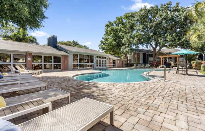 a swimming pool in front of a house with a resort style pool