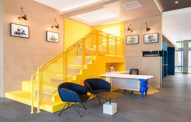 a yellow staircase in a lobby with chairs and a table at The Chase at Bryant Street, District of Columbia