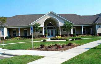 A building with a brown roof and a white sign in front of it.